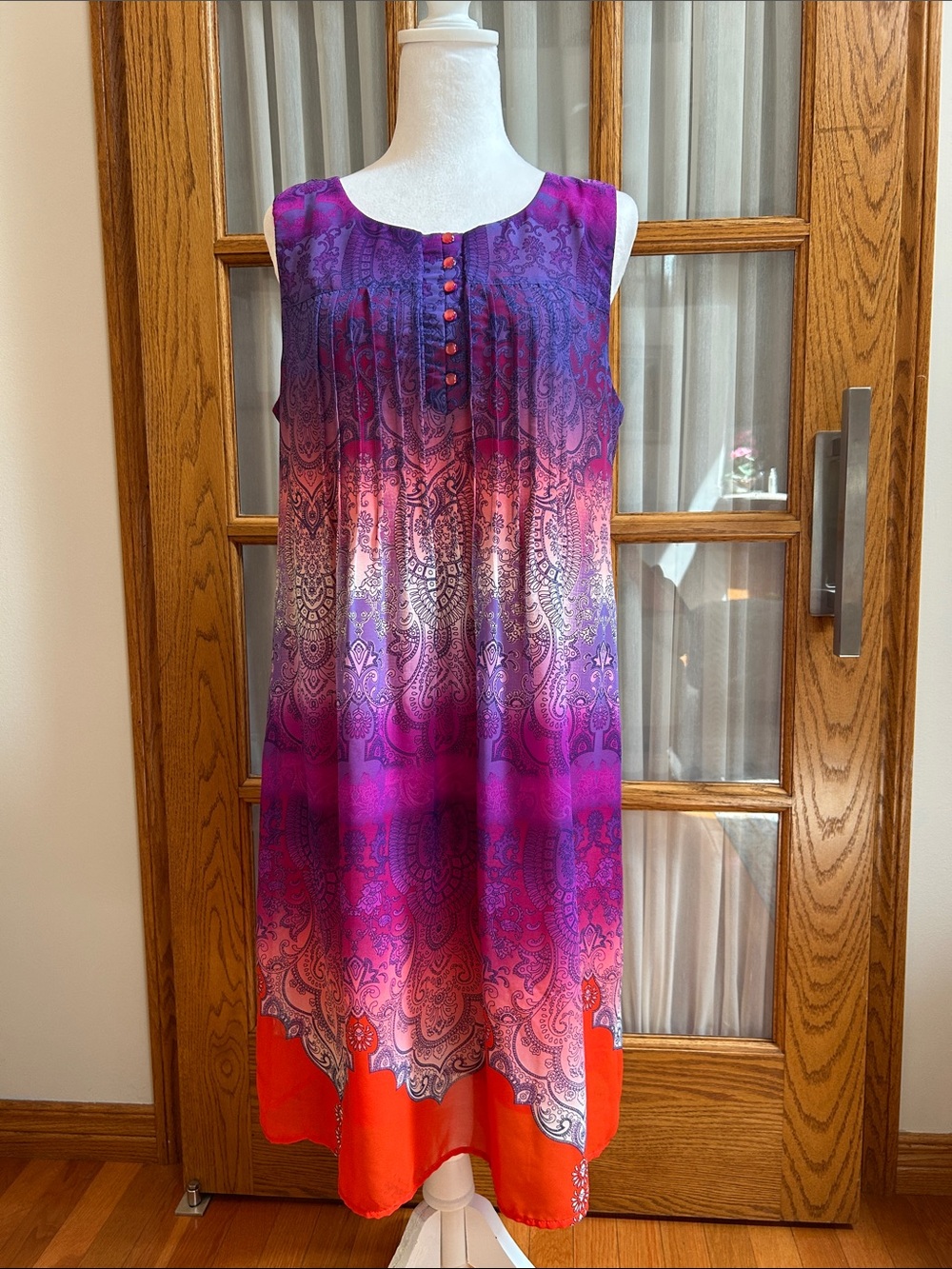 A sweet shear sleeveless dress with orange pearl buttons, by Cris McLaughlin.